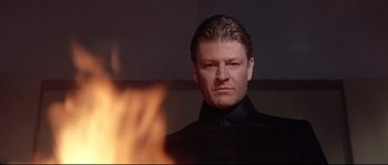 Movie still from “Equilibrium” (2002), directed by Kurt Wimmer – A person wearing a suit and tie; Close Up shot, Low angle