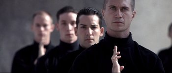 Movie still from “Equilibrium” (2002), directed by Kurt Wimmer – A group of men standing next to each other in black shirts; Close Up shot, Low angle