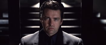 Movie still from “Equilibrium” (2002), directed by Kurt Wimmer – A person wearing a suit and tie; Close Up shot, Low angle