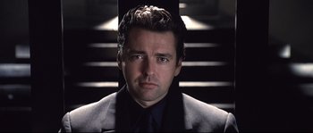Movie still from “Equilibrium” (2002), directed by Kurt Wimmer – A person wearing a suit and tie; Close Up shot, Low angle