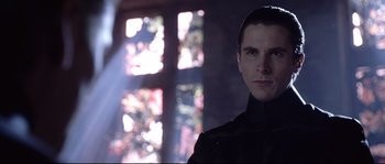 Movie still from “Equilibrium” (2002), directed by Kurt Wimmer – A person wearing a suit and tie; Close Up shot, Low angle