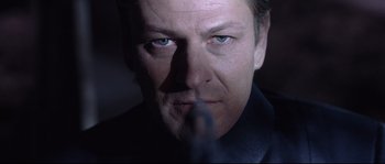 Movie still from “Equilibrium” (2002), directed by Kurt Wimmer – A man's face in a dimly - lit room; Close Up shot, Low angle