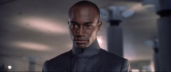 Movie still from “Equilibrium” (2002), directed by Kurt Wimmer – A man in a gray suit is looking straight ahead; Close Up shot, Low angle