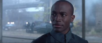 Movie still from “Equilibrium” (2002), directed by Kurt Wimmer – A man in a black shirt is looking to his left; Close Up shot, Low angle