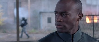 Movie still from “Equilibrium” (2002), directed by Kurt Wimmer – A person wearing a suit and tie; Close Up shot, Over the shoulder angle