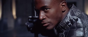 Movie still from “Equilibrium” (2002), directed by Kurt Wimmer – A person wearing a leather jacket; Close Up shot, Low angle