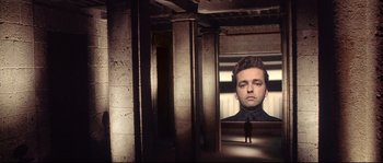 Movie still from “Equilibrium” (2002), directed by Kurt Wimmer – A man in a black shirt is reflected in a mirror; Wide shot, Low angle