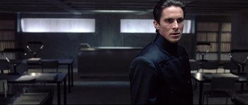 Movie still from “Equilibrium” (2002), directed by Kurt Wimmer – A man standing in a dark room; Medium shot, Over the shoulder angle