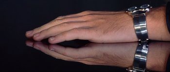 Movie still from “Equilibrium” (2002), directed by Kurt Wimmer – A man's hands are reflected in a mirror; Extreme Close Up shot, Overhead angle