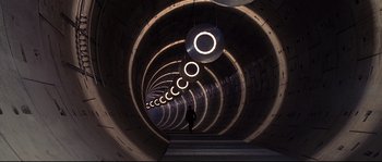 Movie still from “Equilibrium” (2002), directed by Kurt Wimmer – A person is walking in a tunnel with lights on it; Extreme Wide shot, Overhead angle