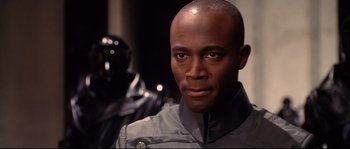 Movie still from “Equilibrium” (2002), directed by Kurt Wimmer – A person wearing a uniform; Close Up shot, Over the shoulder angle