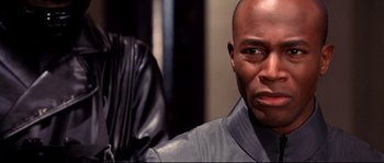 Movie still from “Equilibrium” (2002), directed by Kurt Wimmer – A person wearing a leather jacket; Close Up shot, Over the shoulder angle