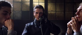 Movie still from “Equilibrium” (2002), directed by Kurt Wimmer – A man talking on a phone while wearing a suit and tie; Close Up shot, Low angle