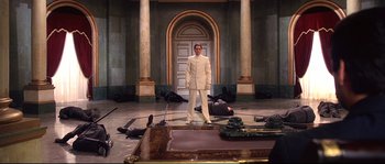 Movie still from “Equilibrium” (2002), directed by Kurt Wimmer – A man in a white suit standing in front of a door; Wide shot, High angle