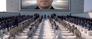 Movie still from “Equilibrium” (2002), directed by Kurt Wimmer – Many people sitting in a room; Extreme Wide shot, High angle