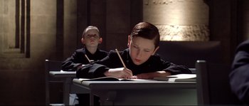 Movie still from “Equilibrium” (2002), directed by Kurt Wimmer – Two young boys are sitting at their desks writing; Close Up shot, High angle
