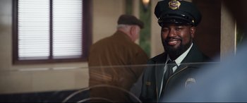 Movie still from “Free Guy” (2021), directed by Shawn Levy – A man wearing a hat and a uniform; Medium shot, Over the shoulder angle