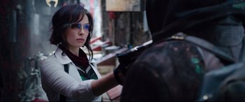 Movie still from “Free Guy” (2021), directed by Shawn Levy – A woman holding a gun while standing next to a man; Close Up shot, Over the shoulder angle