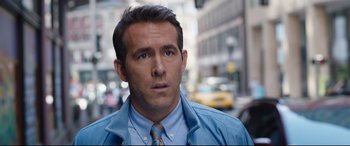 Movie still from “Free Guy” (2021), directed by Shawn Levy – A person wearing a suit and tie; Close Up shot, Over the shoulder angle