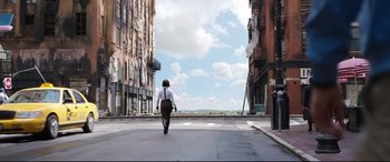 Movie still from “Free Guy” (2021), directed by Shawn Levy – A person walking down a street with buildings in the background; Extreme Wide shot, Low angle