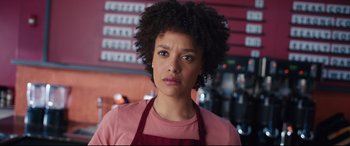 Movie still from “Free Guy” (2021), directed by Shawn Levy – A woman in a pink shirt and a red apron; Close Up shot, Over the shoulder angle