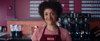 Movie still from “Free Guy” (2021), directed by Shawn Levy – A woman in a pink shirt and a red apron; Close Up shot, Over the shoulder angle