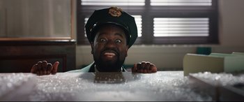 Movie still from “Free Guy” (2021), directed by Shawn Levy – A man in a green hat is sitting at a table; Close Up shot, Low angle