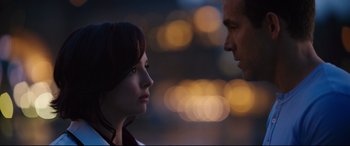 Movie still from “Free Guy” (2021), directed by Shawn Levy – A man and a woman face to face in front of lights; Close Up shot, Over the shoulder angle