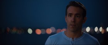 Movie still from “Free Guy” (2021), directed by Shawn Levy – A person wearing a white t - shirt; Close Up shot, Over the shoulder angle