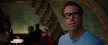 Movie still from “Free Guy” (2021), directed by Shawn Levy – A person wearing glasses and a blue shirt; Close Up shot, Over the shoulder angle