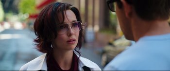 Movie still from “Free Guy” (2021), directed by Shawn Levy – A person wearing glasses near a car; Close Up shot, Over the shoulder angle