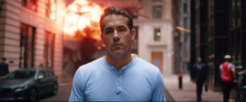 Movie still from “Free Guy” (2021), directed by Shawn Levy – A person wearing a blue t - shirt; Medium shot, Over the shoulder angle