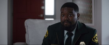 Movie still from “Free Guy” (2021), directed by Shawn Levy – A man sitting on top of a couch wearing a suit; Close Up shot, Over the shoulder angle