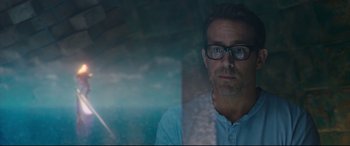 Movie still from “Free Guy” (2021), directed by Shawn Levy – A person wearing glasses and a blue shirt; Close Up shot, Over the shoulder angle