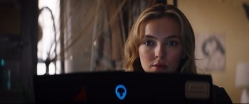 Movie still from “Free Guy” (2021), directed by Shawn Levy – A beautiful young lady sitting in front of a laptop computer; Close Up shot, Over the shoulder angle