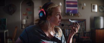 Movie still from “Free Guy” (2021), directed by Shawn Levy – A woman wearing headphones and holding a microphone; Close Up shot, Over the shoulder angle