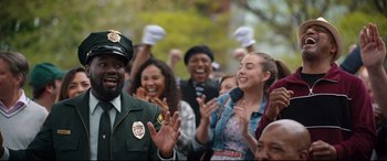 Movie still from “Free Guy” (2021), directed by Shawn Levy – A group of people standing next to each other on a street; Medium shot, Over the shoulder angle