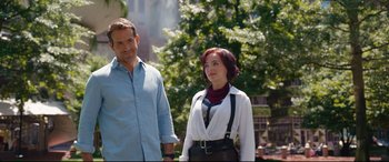 Movie still from “Free Guy” (2021), directed by Shawn Levy – A man and a woman standing next to each other in front of a tree; Medium shot, Over the shoulder angle