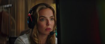 Movie still from “Free Guy” (2021), directed by Shawn Levy – A woman wearing a headset looking at a computer screen; Close Up shot, Over the shoulder angle