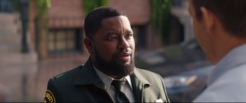 Movie still from “Free Guy” (2021), directed by Shawn Levy – A person wearing a suit and tie; Close Up shot, Over the shoulder angle