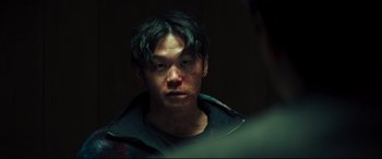 Movie still from “Decision to Leave” (2022), directed by Park Chan-wook – A young man with a bruised face stares at the camera; Close Up shot, Over the shoulder angle