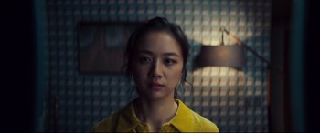 Movie still from “Decision to Leave” (2022), directed by Park Chan-wook – A woman in a yellow shirt is looking at the camera; Close Up shot, Low angle