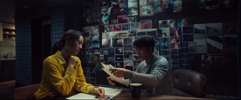 Movie still from “Decision to Leave” (2022), directed by Park Chan-wook – A man and a woman sitting at a table with papers in front of them; Medium shot, High angle