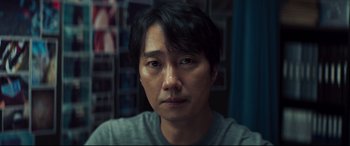 Movie still from “Decision to Leave” (2022), directed by Park Chan-wook – A person wearing a gray shirt; Close Up shot, Over the shoulder angle