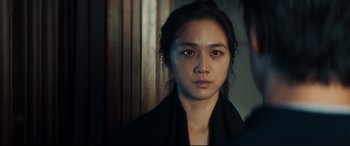Movie still from “Decision to Leave” (2022), directed by Park Chan-wook – A young woman with long black hair wearing a black jacket; Close Up shot, Over the shoulder angle