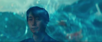 Movie still from “Decision to Leave” (2022), directed by Park Chan-wook – A man is looking at the camera through a glass window; Close Up shot, Low angle