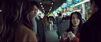 Movie still from “Decision to Leave” (2022), directed by Park Chan-wook – A group of people walking down a busy street; Medium shot, Over the shoulder angle