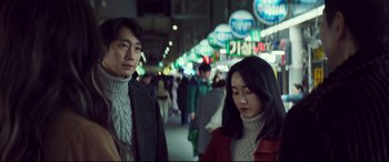 Movie still from “Decision to Leave” (2022), directed by Park Chan-wook – A man and a woman walking down a street; Medium shot, Over the shoulder angle