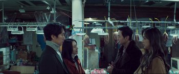 Movie still from “Decision to Leave” (2022), directed by Park Chan-wook – A group of people standing next to each other in a room; Medium shot, Over the shoulder angle