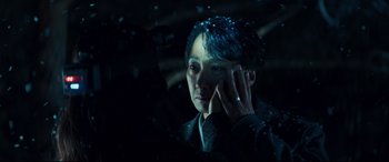 Movie still from “Decision to Leave” (2022), directed by Park Chan-wook – A woman with blue hair looking out of a window; Close Up shot, Over the shoulder angle